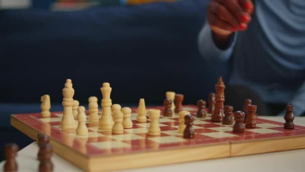 Primo piano della donna nera che muove i pezzi di scacchi a bordo - Filmati, video