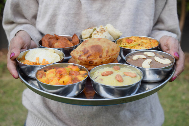 Cocina india de ayuno Upwas items Thali complere meal for vrat ekadashi.Upawas thali meal with Rajgira puri, paratha, shakarkand halwa, alu sabji, amaranth sheera pakoda, sabudana ata dhokla, chips - Foto, imagen
