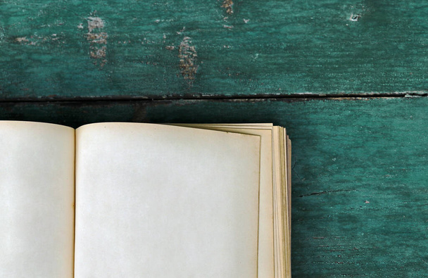 Een oud boek met blanco pagina 's op een blauwe houten achtergrond - Foto, afbeelding