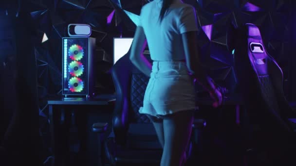 Κορίτσι gamer κάθεται στην καρέκλα στο σύλλογο τυχερών παιχνιδιών και γυρίζει γύρω από το PC - Πλάνα, βίντεο