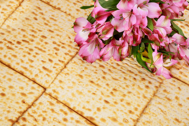 Пасхальный фон с мацей и цветами. Еврейский праздник. - Фото, изображение