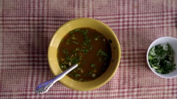 Bowl van Mexicaans rundvlees stoofpot op een wit en rood geruite tafelkleed - Video
