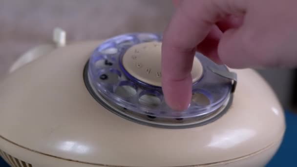 La mano femminile raccoglie il numero di telefono e quadranti sul telefono rotante retrò vintage - Filmati, video