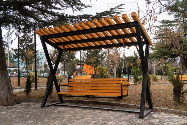 Деревянная скамейка в городском парке, место для отдыха. Цзи - Фото, изображение