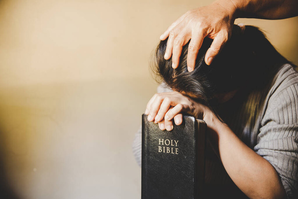 Çift evde İncil okuyup birlikte dua ediyor. İki kişi birlikte dua ediyor. Ellerini kapat. - Fotoğraf, Görsel