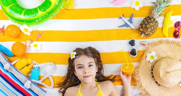 Child girl on a beach towel by the sea. Selective focus. Kid. - Photo, Image