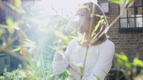 жінка насолоджується миттю в саду
 - Кадри, відео