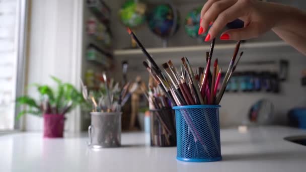 Vrouw die een penseel kiest voor schilderen - Video
