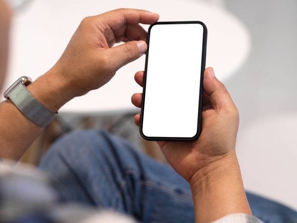 Close up view of man freelancer hands using smartphone with mock up screen in plurred background, ścieżka wycinania - Zdjęcie, obraz