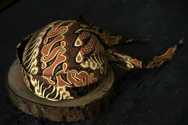 a traditional head covering called Blangkon typical of Indonesian Java. This head cover wears batik cloth and is worn for custom or fashion events. - Photo, Image