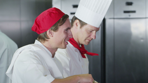 ευτυχής εκπαιδευόμενος σεφ που εργάζονται σε μια επαγγελματική κουζίνα - Πλάνα, βίντεο