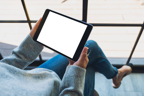 Imagen burlona de una mujer sosteniendo una tableta negra PC con pantalla blanca en blanco  - Foto, Imagen