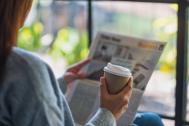 Nahaufnahme einer Frau, die morgens Zeitung liest und Kaffee trinkt - Foto, Bild
