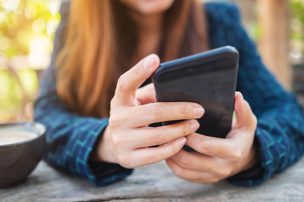 Closeup image of a woman holding and touching on mobile phone screen - Foto, imagen