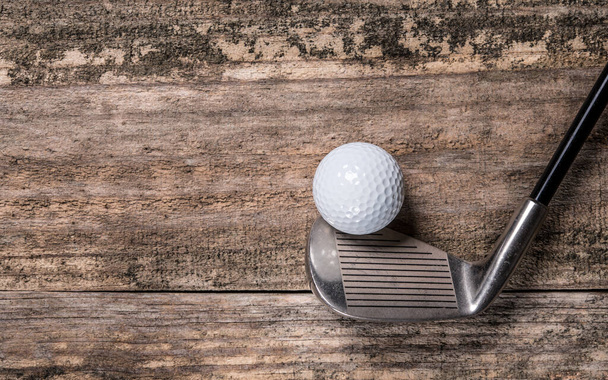Golf ball and club on natural wood table. Sport game. Golf championship. Background with copy space. Macro high resolution photo. - Photo, Image