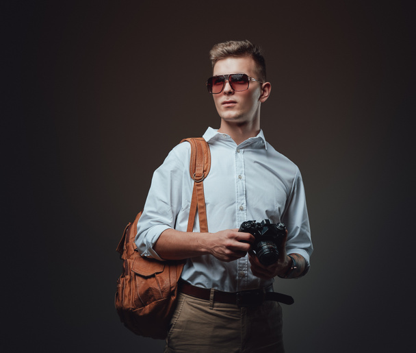 Молодой фотограф в солнечных очках и рюкзаке - Фото, изображение