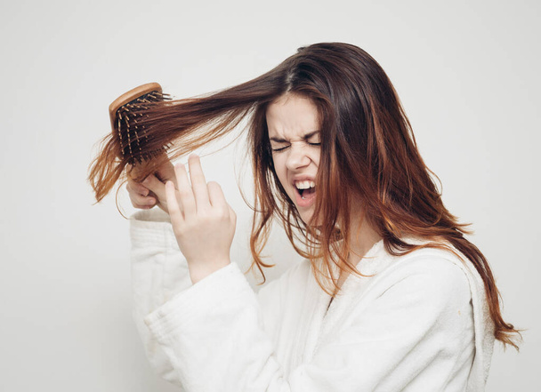 жінка розчісує волосся крихкі кінці розщеплені кінці проблеми зі здоров'ям
 - Фото, зображення