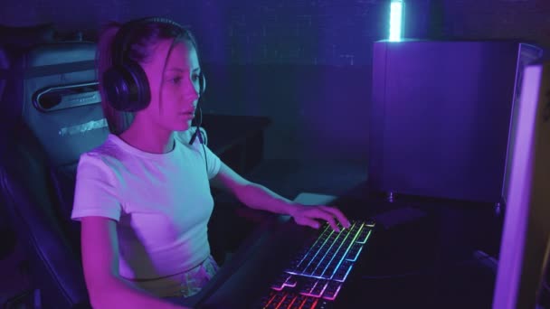 Девушка геймер сидит за компьютером в игорном клубе и играет - проигрывает игру - Кадры, видео