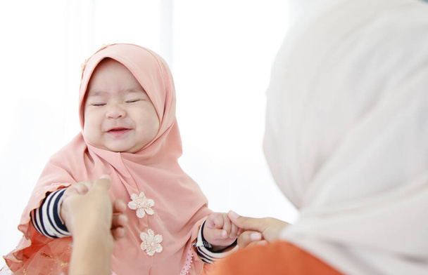 Belle mère musulmane tenant son bébé. Mère de famille musulmane et concept d'enfant vie domestique. - Photo, image