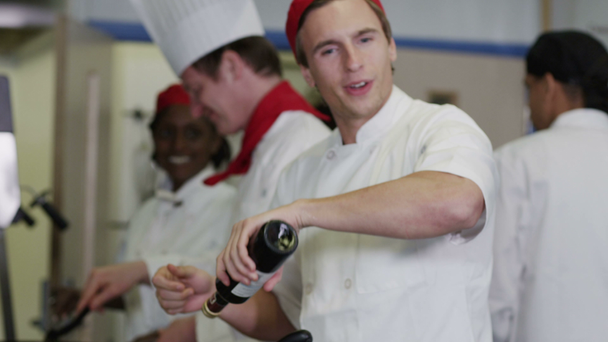 Equipo feliz de chefs en cocina comercial, preparando comida y charlando juntos
 - Metraje, vídeo