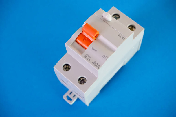 Interruptor automático de corriente diferencial sobre fondo azul. Concepto de ingeniería eléctrica. - Foto, imagen