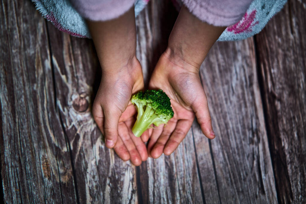 Селективный фокус рук девушки с брокколи для здорового питания - Фото, изображение