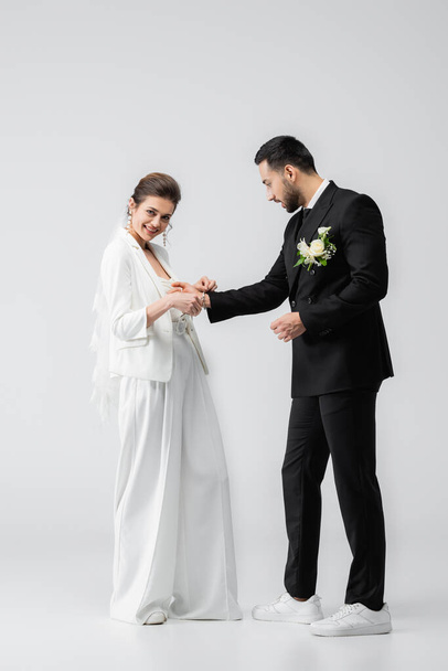 陽気な花嫁身に着けています手錠オンイスラム教徒のボーイフレンドオンホワイト背景 - 写真・画像