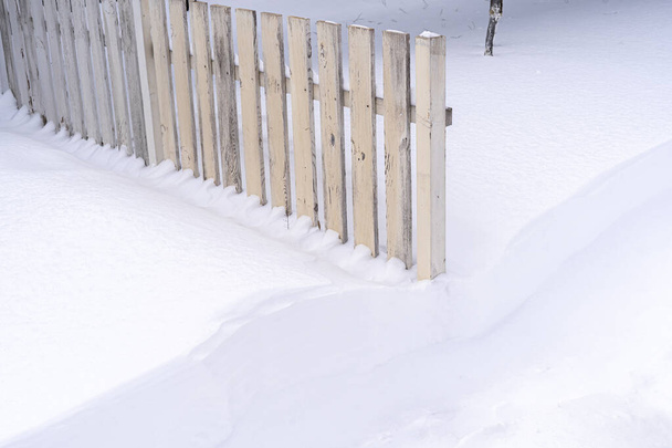 Biały drewniany płot pokryty śniegiem - Zdjęcie, obraz