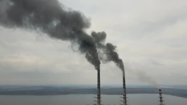 Uitzicht vanuit de lucht op hoge pijpen van kolencentrales met zwarte rook die de vervuilende atmosfeer opgaat. - Video