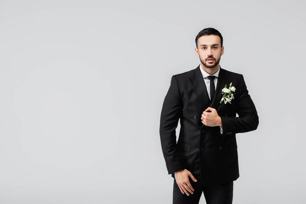 Young arabian groom in suit looking at camera isolated on grey  - Photo, Image