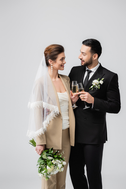 Interrazziale sposi clinking con champagne isolato su grigio  - Foto, immagini