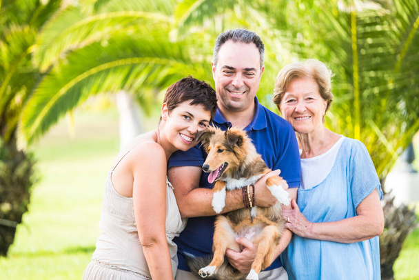 Dog and family human people portrait in outdoor leisure activity together at the park - Photo, Image