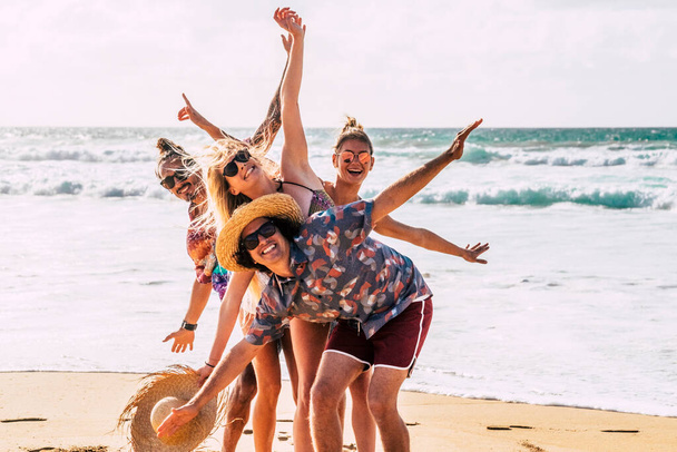 Groep gelukkige Kaukasische jongeren jongens en meisjes veel plezier en genieten van het strand in de zomervakantie samen lachen - Foto, afbeelding