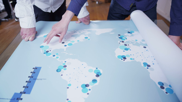 Team aziendale globale che esamina una mappa del mondo
 - Filmati, video