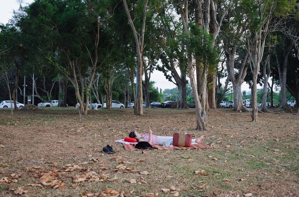 Nuori nainen pelaa älypuhelin ja makaa matto tarvikkeet - Valokuva, kuva
