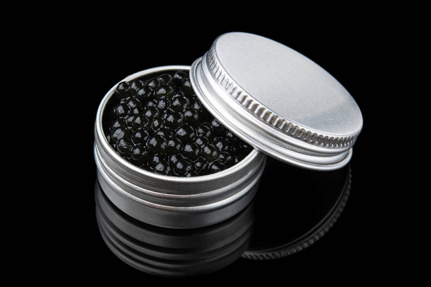 Expensive black sturgeon caviar in metal pan isolated on a black background - Photo, Image