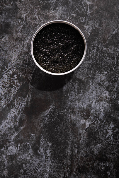 Fish black caviar on a dark stone background. luxury delicatessen and seafood. - Photo, Image