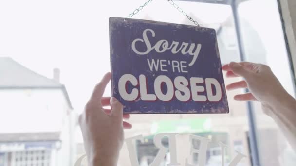 Open' sign is turned to 'Closed' - Materiał filmowy, wideo