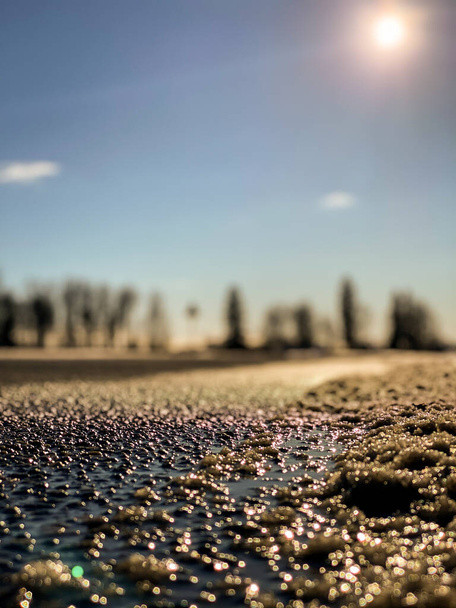 Primer plano macro asfalto textura de la carretera en una puesta de sol de verano naranja por la noche. Fondo borroso - Foto, Imagen