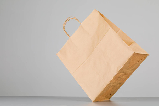 Коричневий паперовий мішок з ручками, порожня торгова сумка з площею для вашого логотипу або дизайну, концепція доставки їжі
 - Фото, зображення