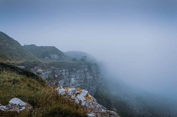 イギリス、ドーセット州ポートランド島のアウト採石場近くの霧の多い天気の間にジュラシック海岸の崖のトップビュー - 写真・画像
