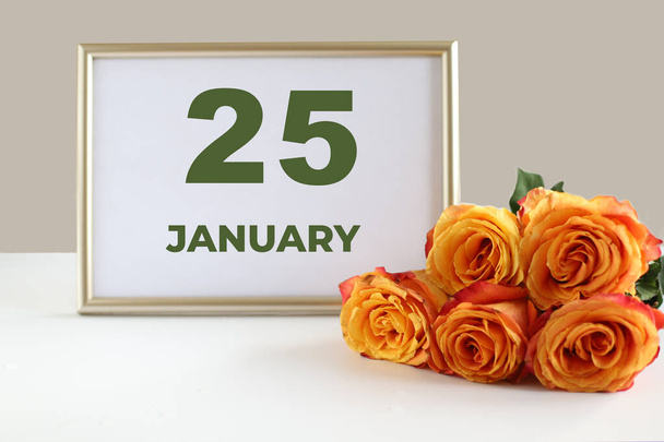 a hónap napja január 25-e naptárkép keret és sárga rózsa fehér asztalon. - Fotó, kép