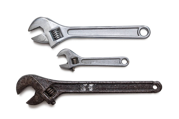 Trzy regulowane klucze, dwa chromowane i jedno zardzewiałe narzędzia hydrauliczne i ślusarskie, izolowane na białym tle - Zdjęcie, obraz