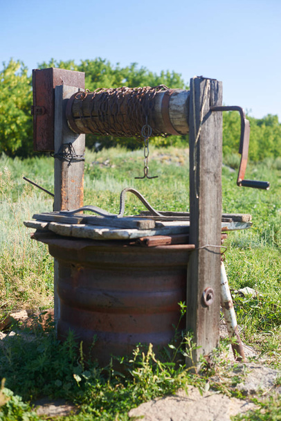 Moderne rustikale hölzerne Wasserentnahme Brunnen Rostige Kette - Foto, Bild