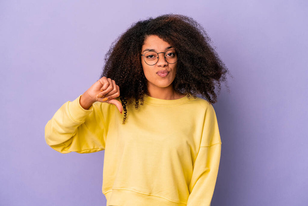 Молода афроамериканська кучерява жінка ізольована на фіолетовому фоні з великим пальцем вниз, розчарування концепції. - Фото, зображення
