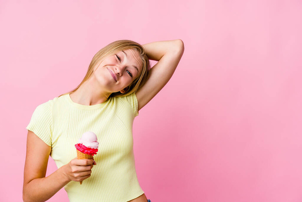 Молода російська жінка, яка їсть морозиво, відокремлена, торкаючись потилиці, думає і робить вибір.. - Фото, зображення
