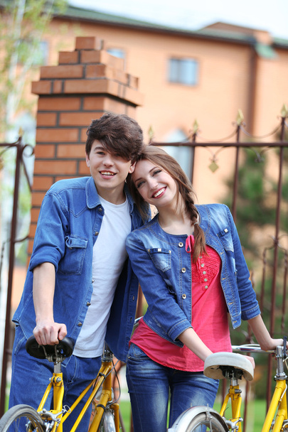νεαρό ζευγάρι με τα ποδήλατα έξω από - Φωτογραφία, εικόνα