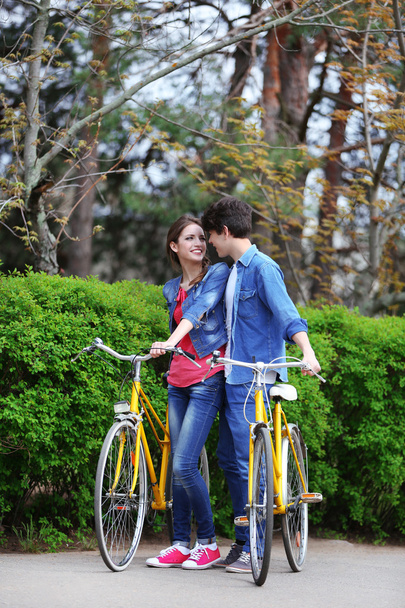 Young couple with bicycles in park - Fotoğraf, Görsel