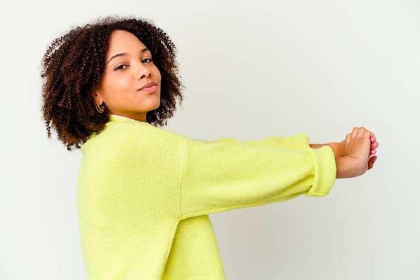 Joven africana americana mixta raza mujer aislado estiramiento brazos, posición relajada. - Foto, imagen