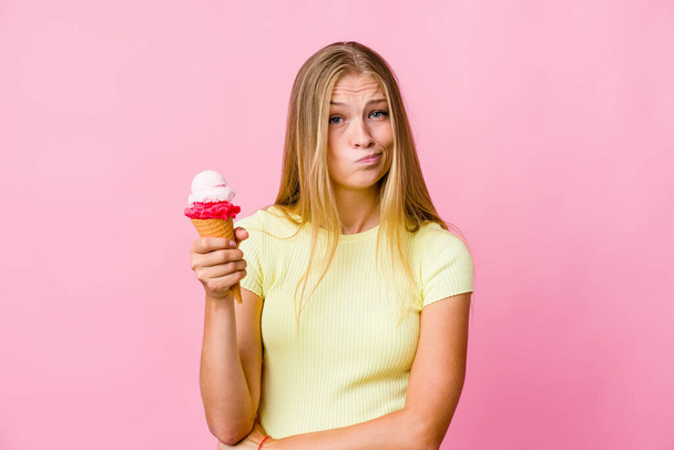 Fiatal orosz nő eszik egy fagylaltot elszigetelt boldogtalan néz a kamera szarkasztikus kifejezés. - Fotó, kép